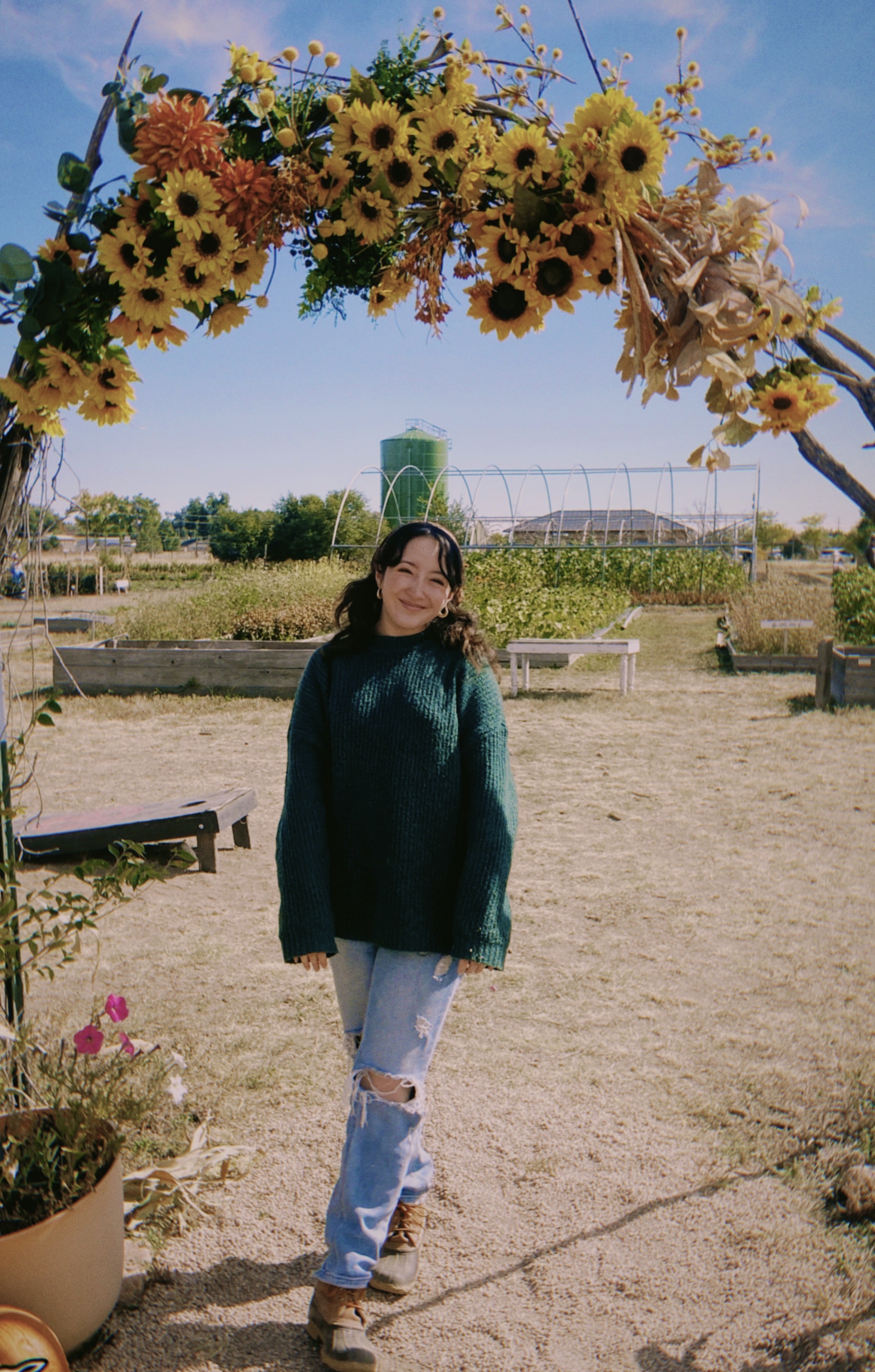 Riley is standing under a flower arc.